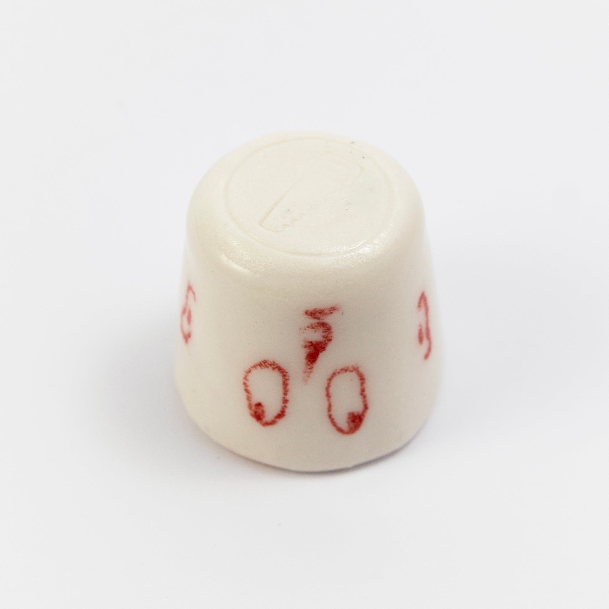 Bottom of the cup showing the full red doodle face (eyes, nose, ears) and a subtle maker’s stamp impression on the base.