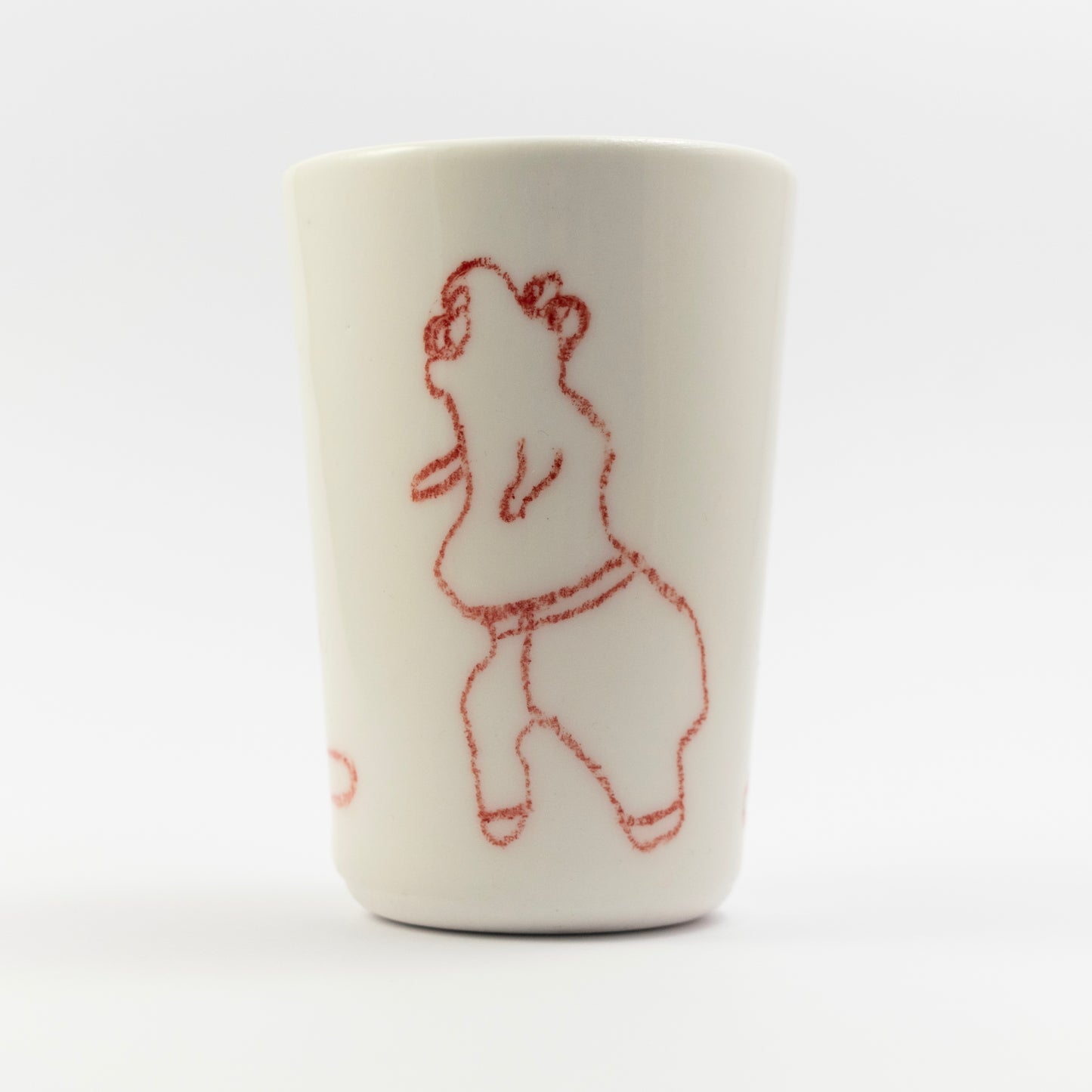 Red underglaze pencil drawing of a curvy, dancing or leaning figure on the side of the tumbler.