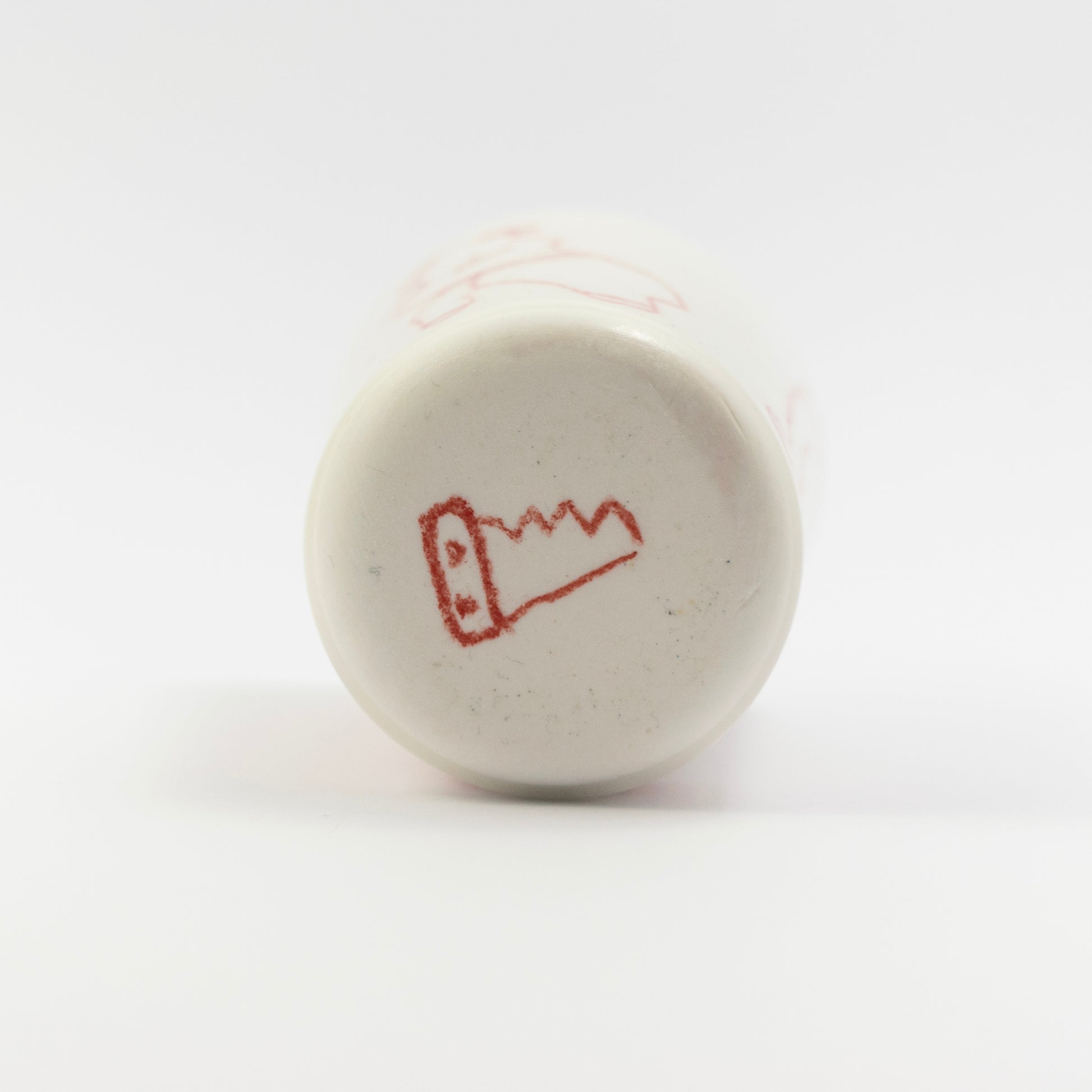 Bottom of the tumbler showing a red doodle resembling a cartoon saw (sawramics logo)