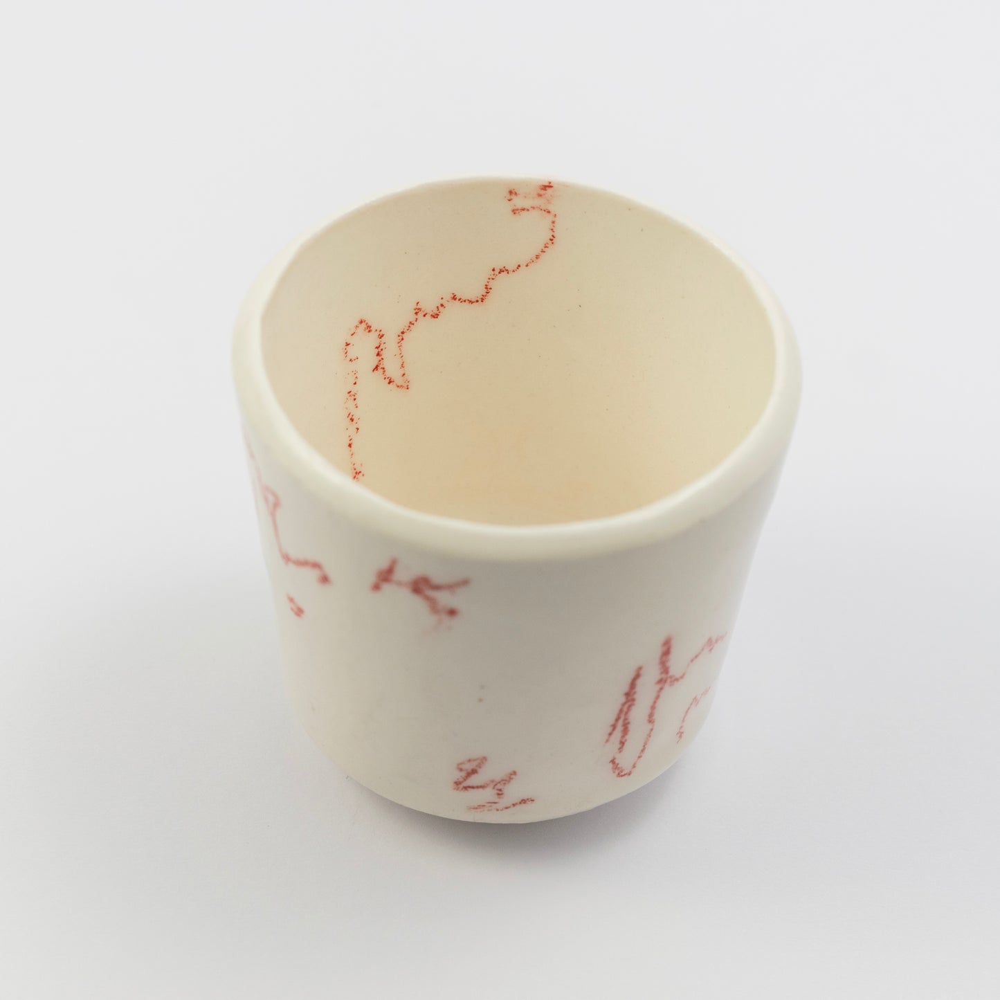 Top-down angle showing the inside of the cup with a red squiggle along the inner rim.