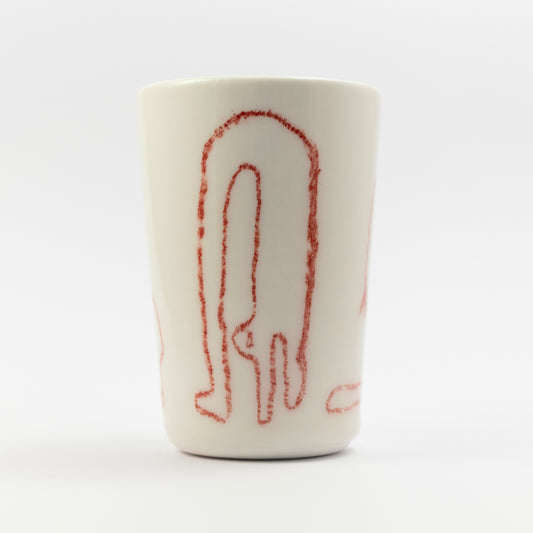 Porcelain tumbler with a tall, abstract red line drawing of a standing figure using underglaze pencil.